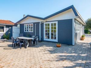 グレーノにある6 person holiday home in Grenaa-By Traumの家の前にテーブルと椅子が置かれたパティオ