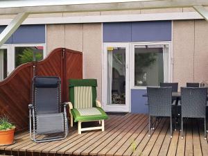 Neksøにある4 person holiday home in Nexø-By Traumの家の上に椅子とテーブル付きのデッキ
