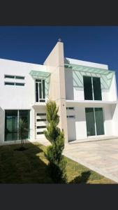 a white building with a tree in front of it at House near IMSS Trinidad Santa Cruz Tlaxcala in Santa María Atlihuetzián