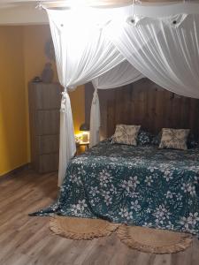 a bedroom with a bed with a canopy at Ti’Bou des Îles de Guadeloupe in Le Moule