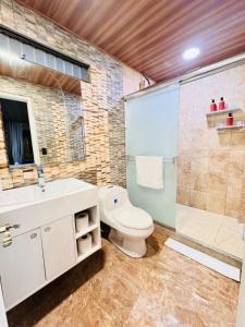 a bathroom with a toilet and a shower and a sink at Casa Costa Rica in Jacó +8 photos
