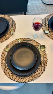 a table with a black plate and a glass of wine at Duna & Mar I Concon in Concón +53 photos