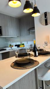 a kitchen with a table with glasses and wine bottles at Duna & Mar I Concon in Concón