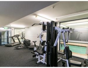un gimnasio con varias máquinas de correr y una piscina en Family friendly 2 bed apartment with carpark, en Wellington