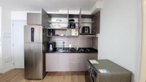 a small kitchen with a stainless steel refrigerator at Apartamento perfeito para sua estadia! in Bauru +37 photos