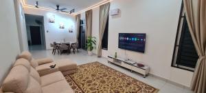 a living room with a couch and a tv and a table at RuzZana Signature Stay Semi-D Corner Lot-BBQ,Wifi,6-8pack in Kota Tinggi