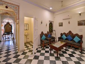 ein Wohnzimmer mit 2 Stühlen und einem Schachbrettboden in der Unterkunft Hotel O Tordi Haveli in Jaipur
