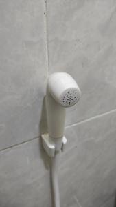 a white hairdryer on the side of a wall at Linda Homestay in Praya +11 photos