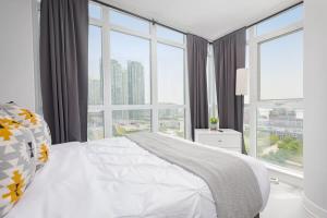 een slaapkamer met een wit bed en een groot raam bij Toronto Getaway 2BR Condo w City Views in Toronto +26 foto's