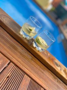 three wine glasses sitting on top of a wooden bench at L ombre du manguier in Grand-Bourg