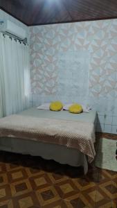 a bedroom with a bed with two yellow pillows at Elizondo Pousada Dr Dionisio Bentes in Belém