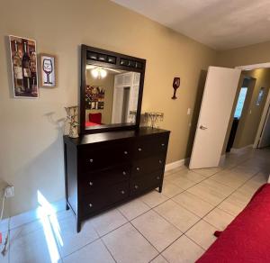 a bedroom with a dresser with a mirror on it at Lovely 2 Bedroom Condo With Free Parking & Wifi!! in Sunrise