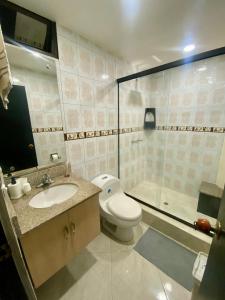 a bathroom with a toilet and a sink and a shower at Apartamento Central Envigado in Envigado