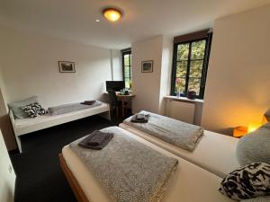ein Zimmer mit drei Betten und einem Schreibtisch darin in der Unterkunft Altes Bierhaus Hotel Zimmervermietung in Arzbach