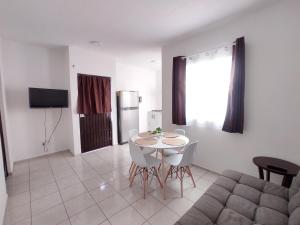 a living room with a table and a refrigerator at Departamento Luz de Lino in Guadalajara