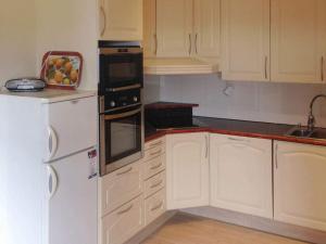 a kitchen with white cabinets and a bowl of fruit on the counter at 7 person holiday home in BREIVIKBOTN 