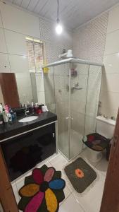 a bathroom with a shower and a sink and a toilet at Pousada Hostels Foryou in Ibiraçu
