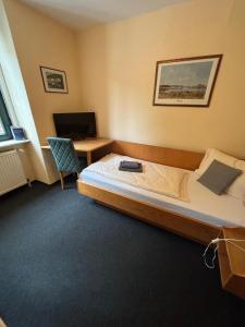ArzbachにあるHotel Bierhausのベッドとパソコン付きの机がある寝室