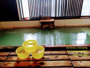 a pool of water with two buckets on a wooden floor at 蔵王温泉 林檎屋 in Yamagata