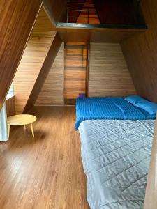 a attic bedroom with a bed and a table at Biển Hồ Garden Glamping in Bien Ho