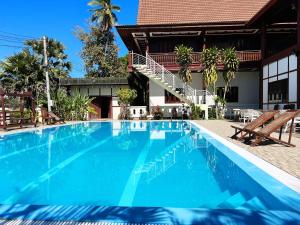 a large blue swimming pool next to a building at Kongmany Prestige Hotel in Muang Không