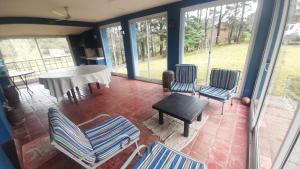 a screened in porch with chairs and a table at La de la LELA in Ciudad Universitaria