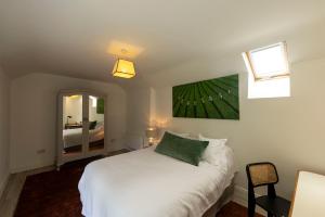 a bedroom with a white bed and a mirror at The Cottage at Lennaght in Inistioge