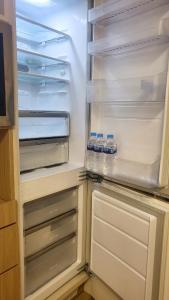 an empty refrigerator with its door open with water bottles in it at #Long-term accommodation inquiries#Suwon Convention Center#Gwanggyo Lake Park#Daily bedding change in Suwon +8 photos