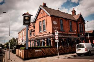 a building on the corner of a street with a car parked in front at The Queen's Head in Kingston upon Thames