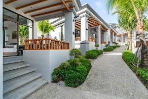 ein Haus mit Palmen und einem Gehweg in der Unterkunft AZ Sunrise Resort & Fitness Club in Layan Beach