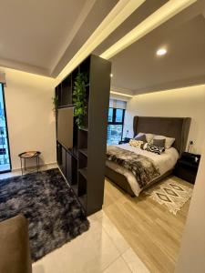 Un dormitorio con una cama grande con una planta. en Cielito Lindo Studio in the heart of Chapultepec, en Guadalajara
