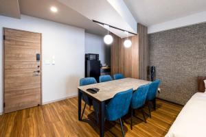 a dining room with a table and blue chairs at Amp Flat Arc Bliss 2A in Chikushino