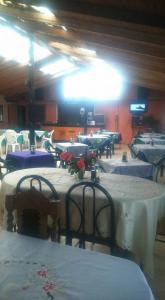 a room with rows of tables with white table cloth at Pensión Hospital in Maipo