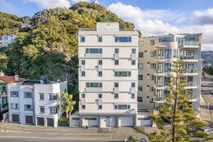 an apartment building in front of a mountain at Luxury Beachfront Apartment in Wellington