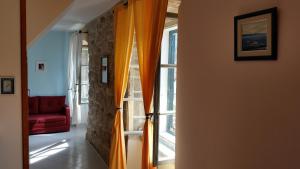 a room with a window with orange curtains and a red couch at Buena Vis-ta Apartments with the Sea View in Vis