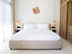 a bedroom with a large bed with white sheets at Aquae Villas - Lavanda - Chic Villa 2 bdr - pool - Kuta Lombok in Kuta Lombok