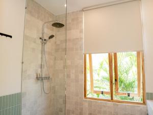 a bathroom with a shower with a window at Aquae Villas - Lavanda - Chic Villa 2 bdr - pool - Kuta Lombok in Kuta Lombok