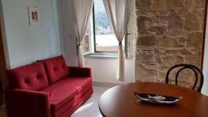 a living room with a red couch and a table at Buena Vis-ta Apartments with the Sea View in Vis