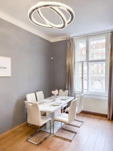 ein Esszimmer mit einem weißen Tisch und weißen Stühlen in der Unterkunft Josefov Riverside Apartment in Prag