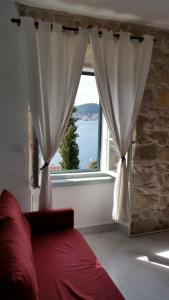 a bedroom with a window with a view of the water at Buena Vis-ta Apartments with the Sea View in Vis