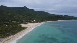 にあるNenas Homestayの青い海水の海岸の空中風景