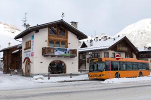 an orange bus is parked in front of a building at Chalet Irene Livigno in Livigno +24 photos