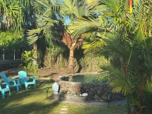 帕帕拉Fare blue Maeva的院子里有一个游泳池，有两把蓝色的椅子和棕榈树