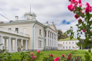 un gran edificio blanco con columnas y flores rosas en Sanatoriy Valuevo, en Valuyevo