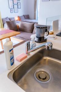 Un fregadero de cocina con una cafetera encima. en 海と山の見える部屋 2BR Canal View, en Otaru