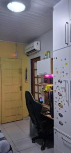 an office with a desk and a chair and a refrigerator at Minha morada in Ananindeua