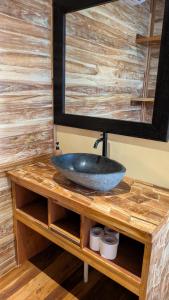 a bathroom sink on a wooden counter with a mirror at Divine Divers Gili Meno in Gili Meno