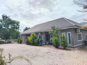 a house with a brick driveway in front of it at Homestay Azkha in Langkawi Islands