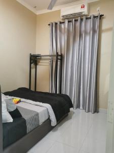 a bedroom with a bed and a window with curtains at Homestay Azkha in Langkawi Islands
