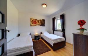 a bedroom with two beds and a window at JD Apartamenty - Klimatyzacja, basen, parking i wifi w cenie in Mysłakowice